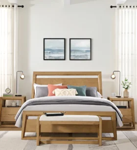 Bedroom furnished with a matching wood furniture set, including a bed frame, bench and bedside tables, in a bright room with large windows and neutral décor.