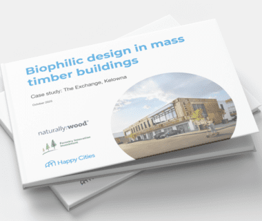 Stack of printed reports titled “Biophilic design in mass timber buildings,” featuring a case study of The Exchange in Kelowna. The cover shows a circular photo of a modern, two-storey mass timber building with wood cladding and large windows, set along a street with a vehicle and a passing cyclist. Logos for naturally:wood, Forestry Innovation Investment, and Happy Cities appear at the bottom, with “October 2025” noted beneath the subtitle.