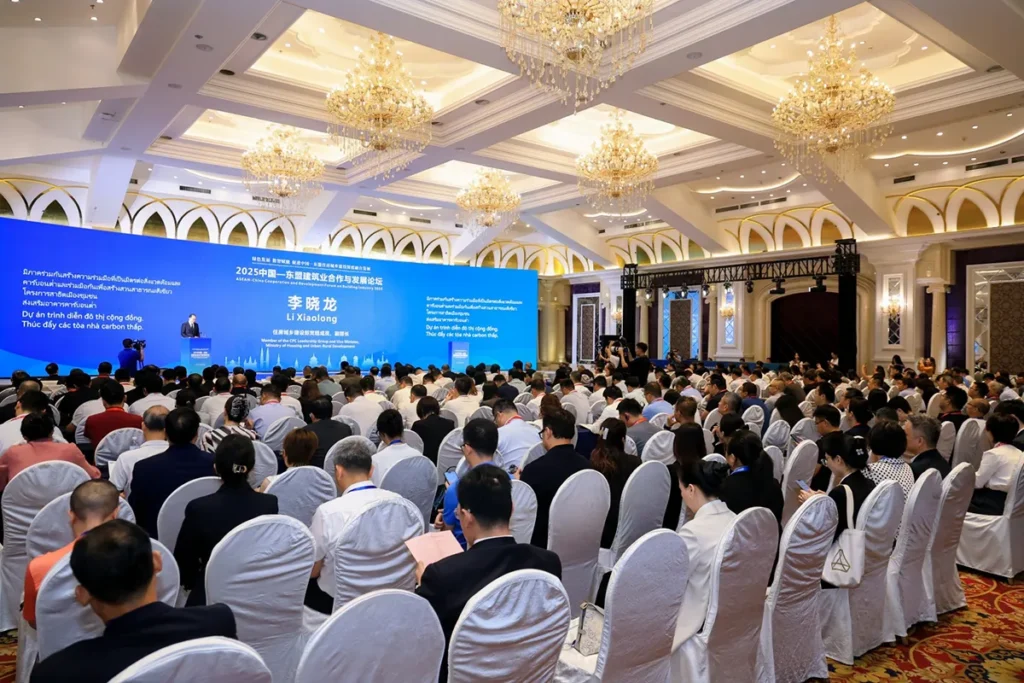 Attendees gather at the 2025 ASEAN-China Concrete and Low-Carbon Development Forum, where a speaker presents to a large audience in a conference hall.