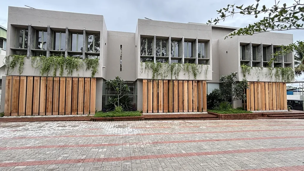 Modern commercial building featuring vertical wood louvre screens across the ground-floor façade, showcasing the natural colour and texture of wood against a light-coloured exterior.